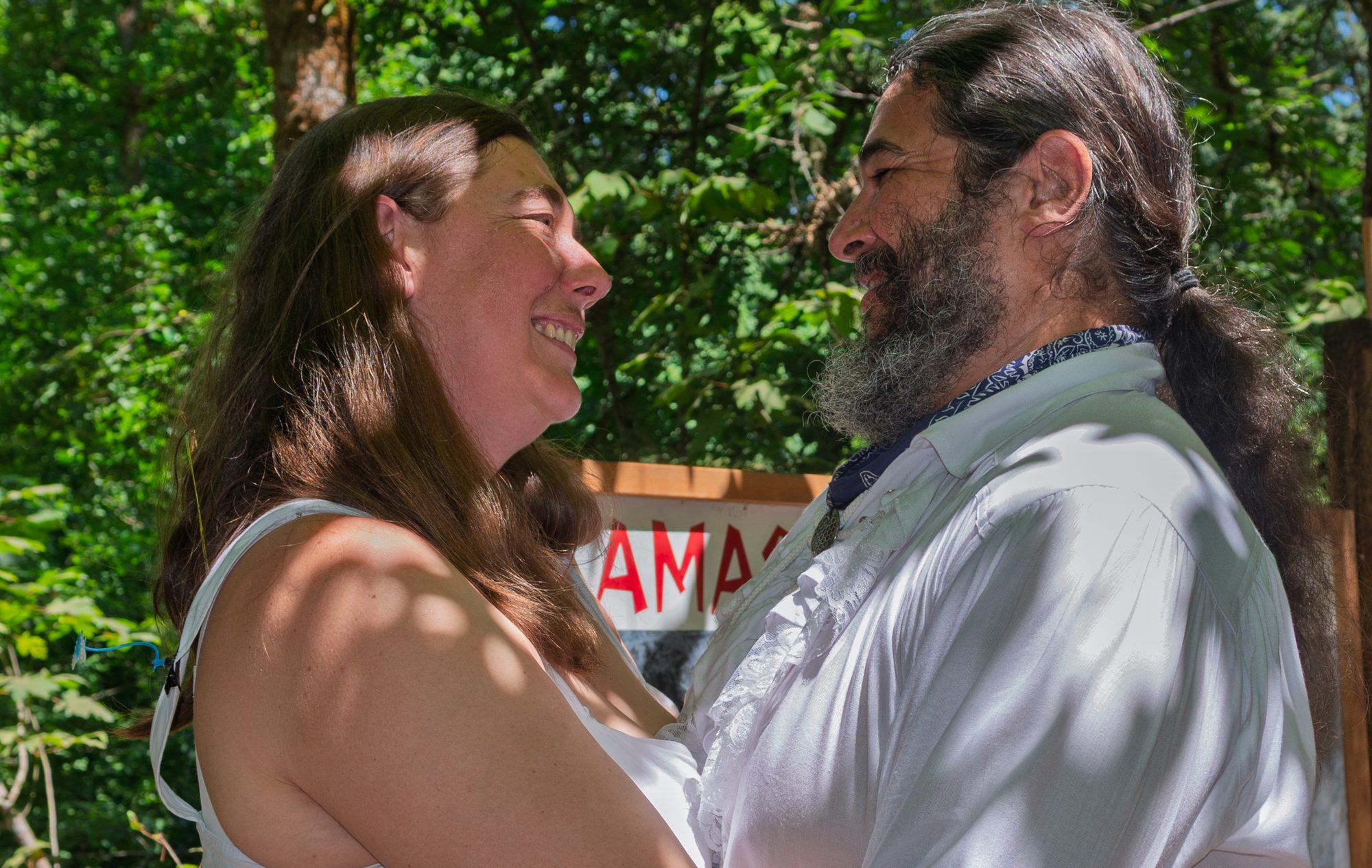 Michelle and Ariel laughing together on their wedding day in the forest